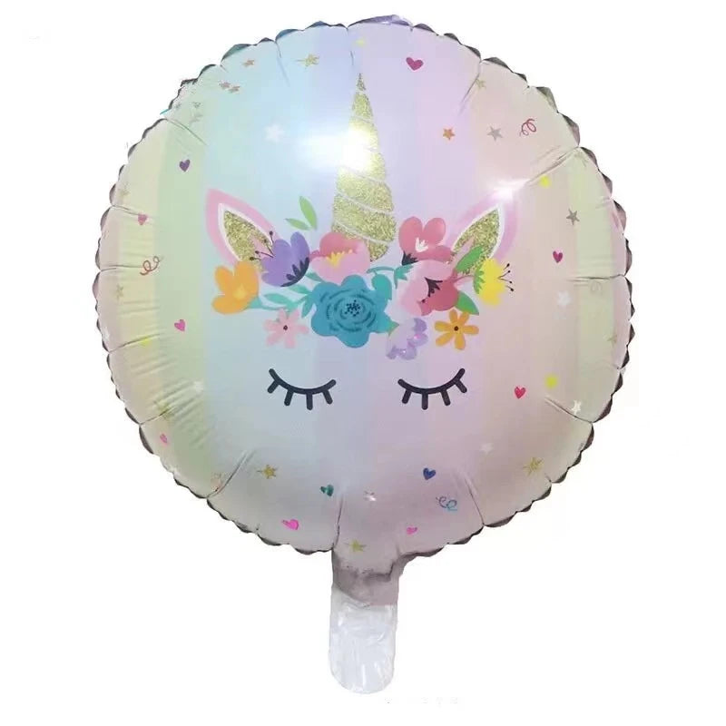 Unicorn face balloon floating above a birthday party table