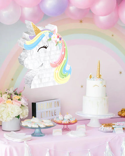 Gold glitter horn and white paper face of the unicorn pinata