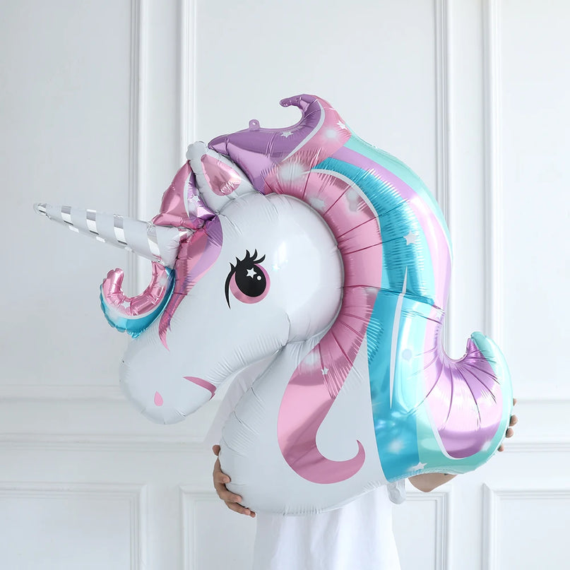 Unicorn head foil balloon held in a hand, showing the pastel gradient mane