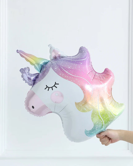 White unicorn shape foil balloon with pastel rainbow mane and pink cheeks