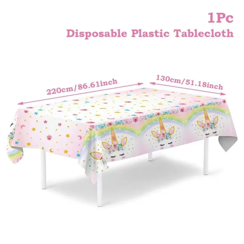 Rainbow unicorn tablecloth in white with pastel rainbow border and gold stars on a party table
