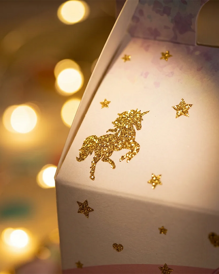 Several unicorn favor boxes arranged on a party table
