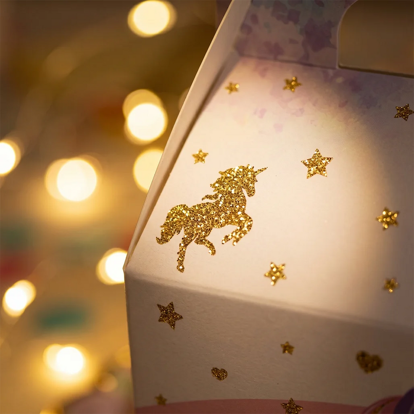 Several unicorn favor boxes arranged on a party table