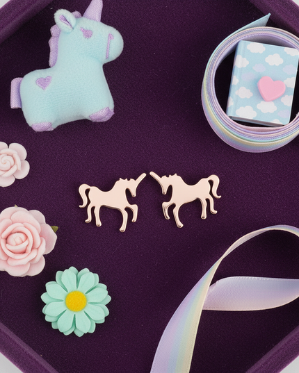 pink steel unicorn earrings - flat-lay