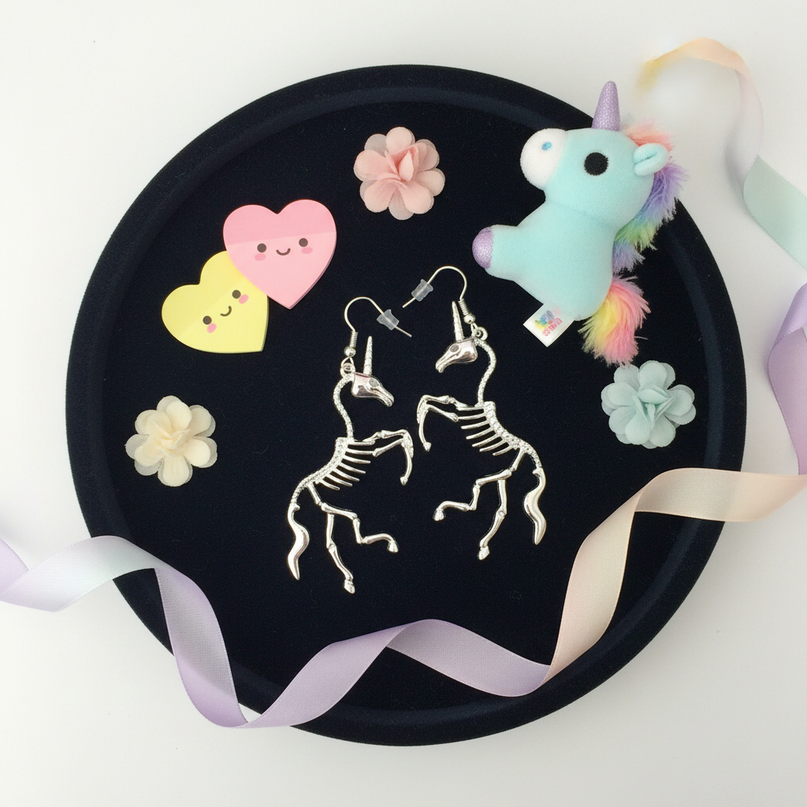 skeleton unicorn earrings - flat-lay